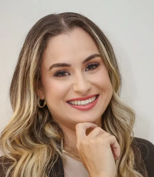 Dra. Jamile Varnier sorrindo, com a mão no queixo