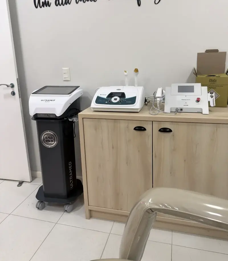 Sala com equipamentos estéticos e frase na parede